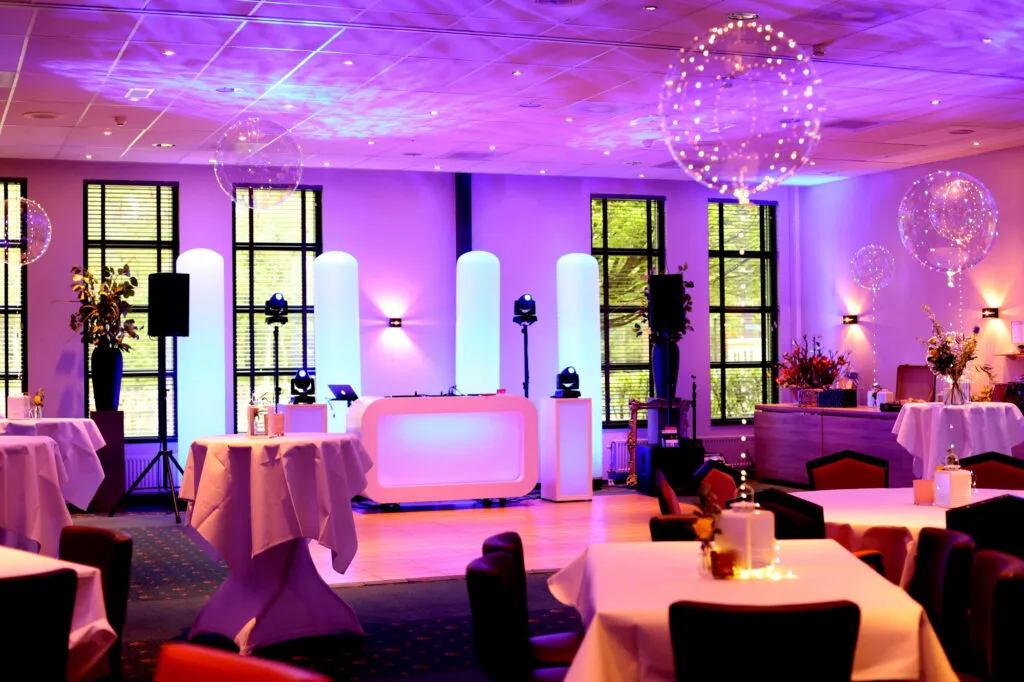 Witte hoogglans DJ-booth met LED-verlichting op een feestvloer
