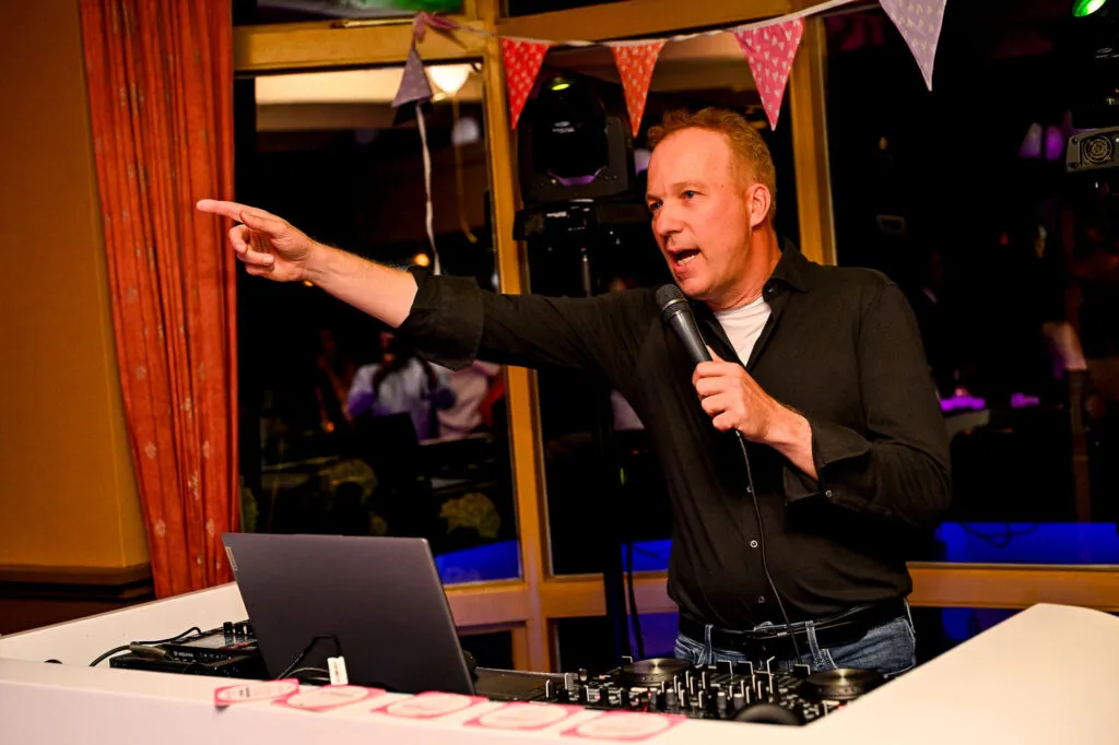 DJ Fokko met microfoon wijst naar de gasten achter de DJ-booth op Landgoed Stania State