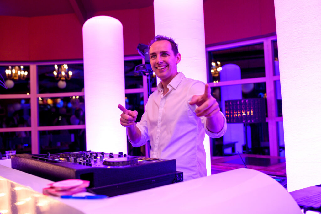 DJ Hendrik wijst lachend naar de dansvloer achter de DJ-booth op Landgoed Stania State