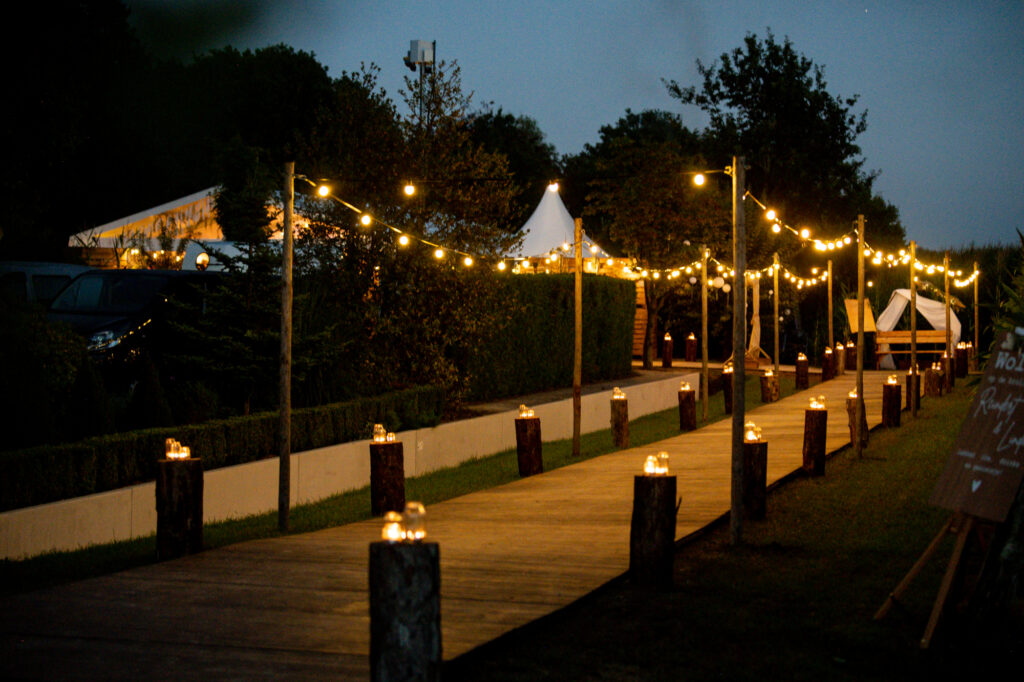 Pad met lichtjes naar een feesttent in de avond