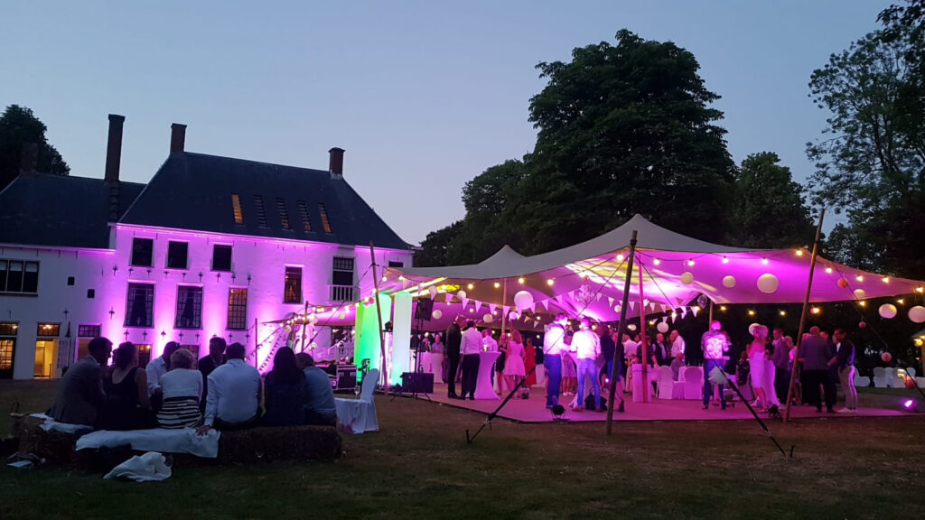 Feesttent met kleurrijke uplights langs de tentwanden