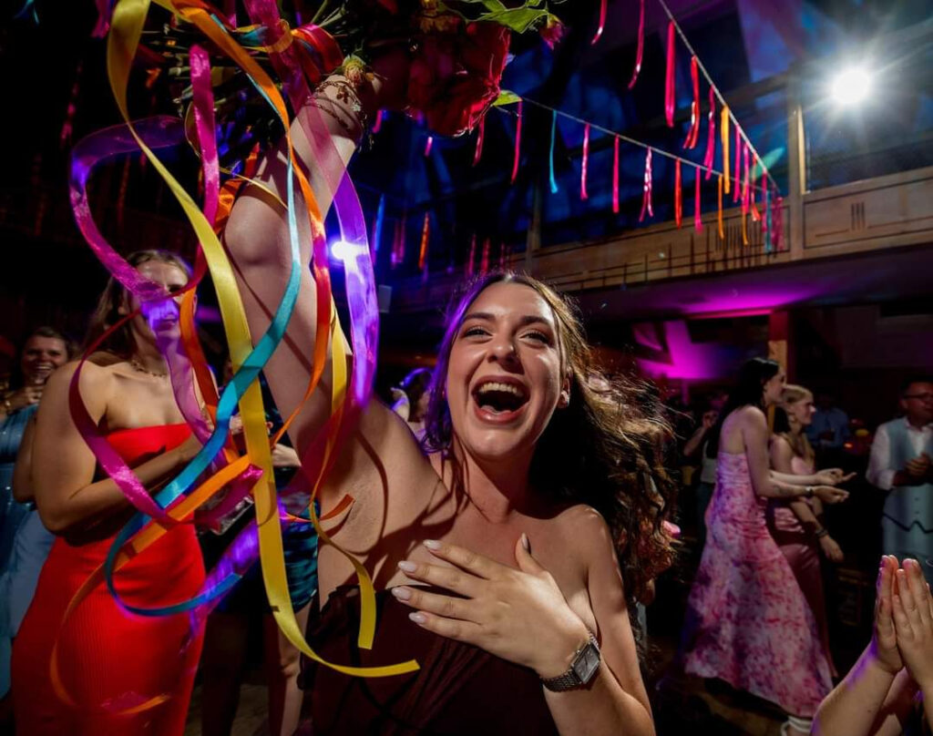 Lachende vrouw met kleurige linten op de feestelijke dansvloer