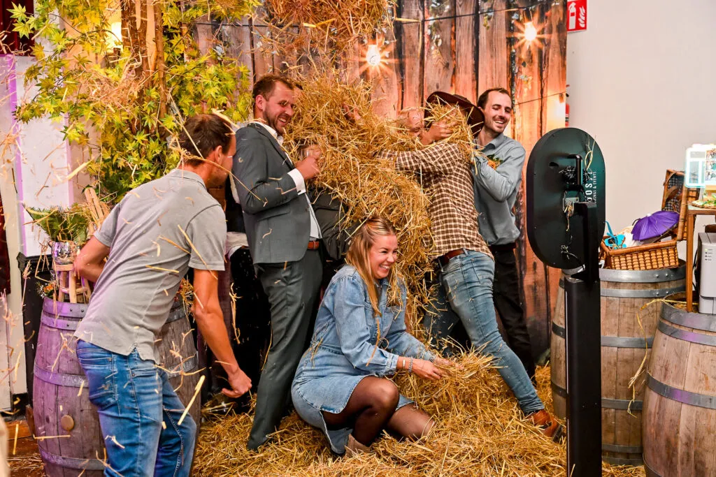 Gasten poseren uitgelaten bij de photobooth tussen de strobalen