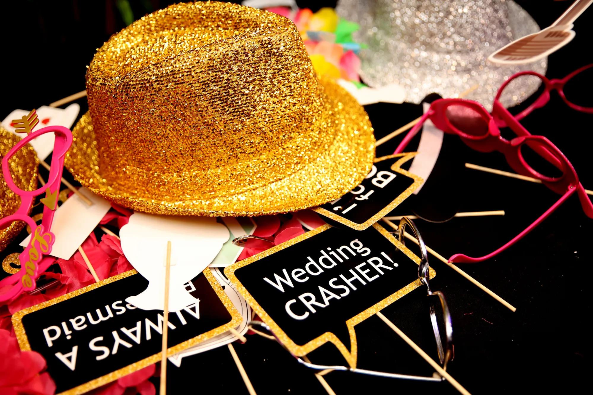 Photobooth-props: een gouden hoed, brillen en bordjes zoals Wedding crasher!