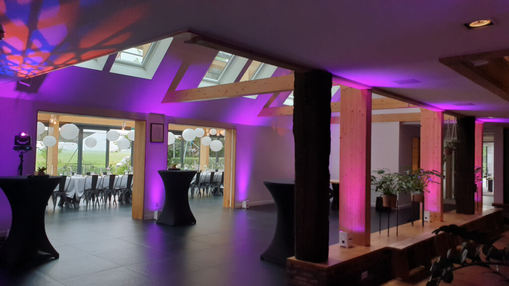 Zaal van de Pollepleats met paarse uplights langs de houten balken