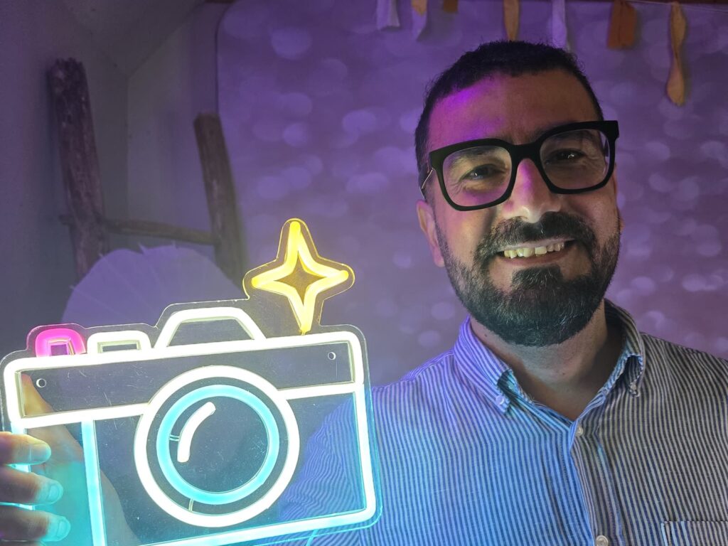 Partyfotograaf met een neonlamp in de vorm van een camera