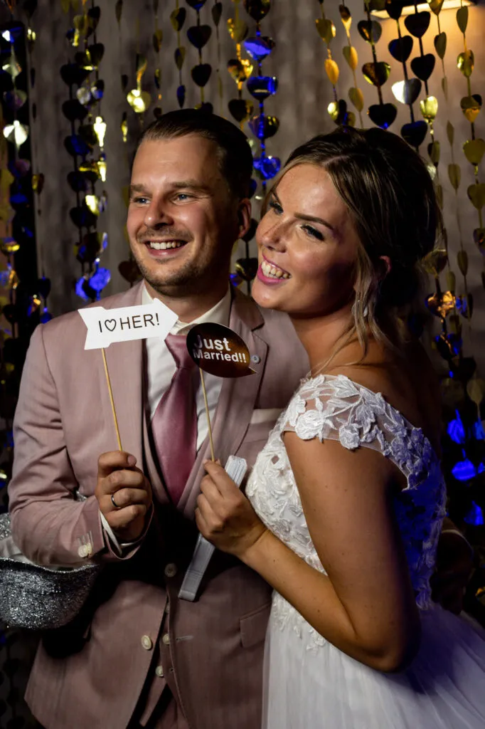 Bruidspaar poseert met props in de photobooth