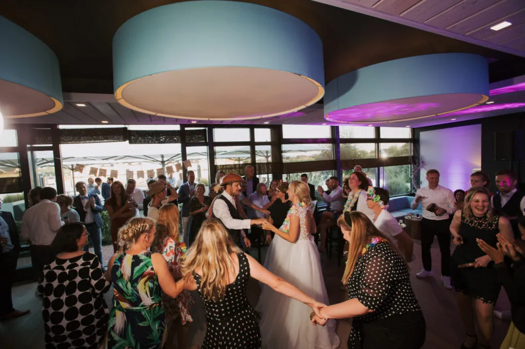 Feestzaal van Villa Bodelaeke met dansende gasten en uitzicht op het water