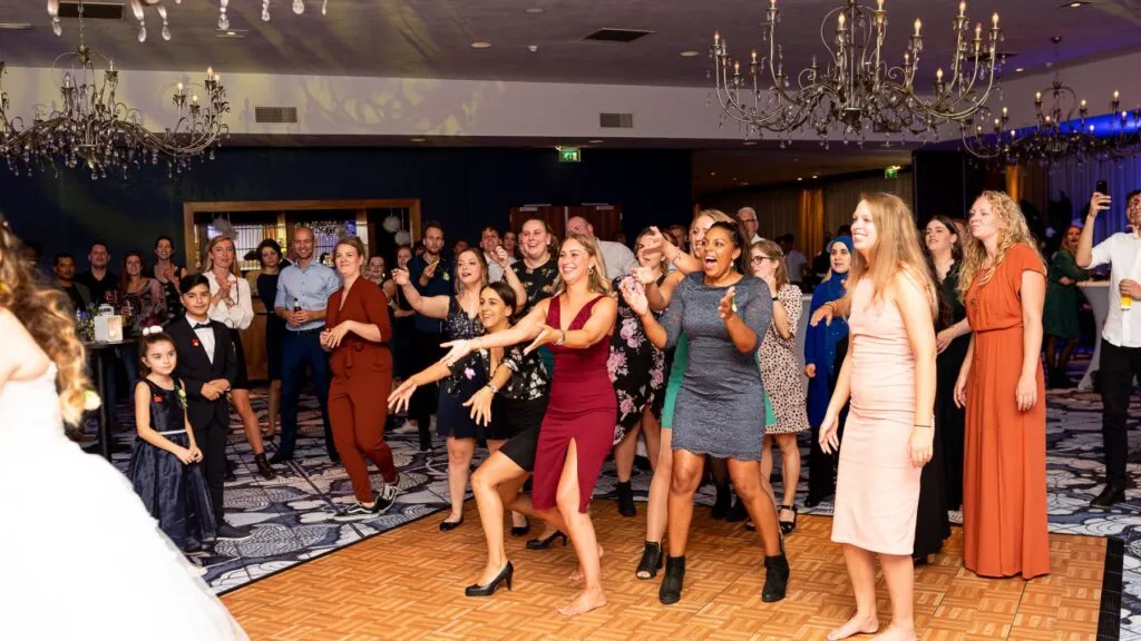 Gasten dansen bij het gooien van het bruidsboeket bij Van der Valk Wolvega